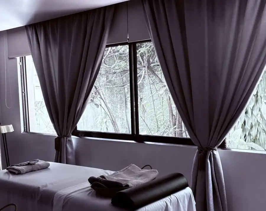 Sala de tratamiento con cortinas abiertas hacia el jardín